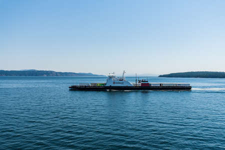 VANCOUVER, CANADA - JUNE 29, 2021: ocean strait in western canada with little old ferry.のeditorial素材