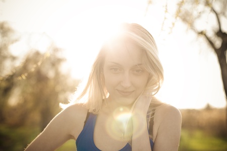 Beautiful blonde girl model looks away in the sun raysの写真素材