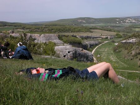 Woman lying at long-awaited halt in mountainの写真素材