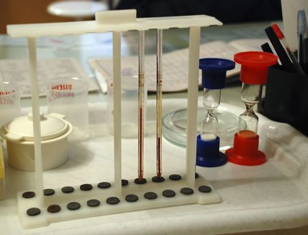 Medical equipment and sand-glasses on white table