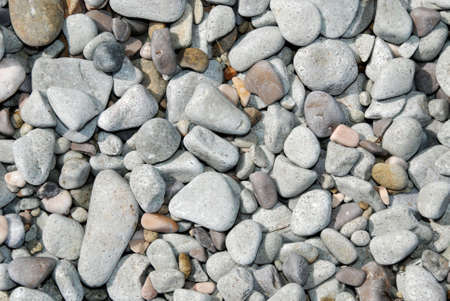 Grey and white pebble background on coastline