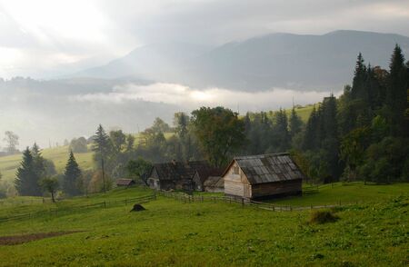 Beautiful landscape in green Carpatian mountains with hills and housesの写真素材