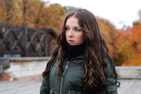 Young cute girl with long dark hairs. Fall. Autumn. Outdoor session.  の写真素材