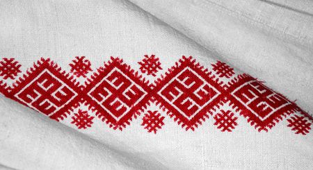 Red embroidery pattern on white fabric, close-upの写真素材
