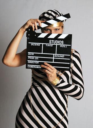 Model in stripy black-and-white dress and cap looks narrowly, face closed with cinematographic beatの写真素材