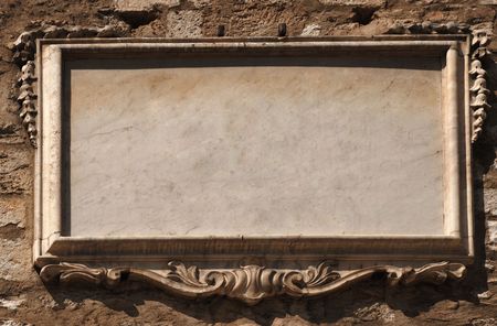 Empty marble tablet decorated with modelling on old stone wall の写真素材