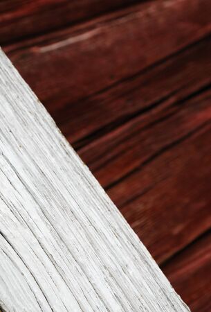 Wood plank is placed diagonally. It is photographed closely and against the wooden wall blurred. The stained board is weathered and chapped. There is copy space.の写真素材