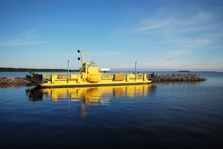 Yellow ferry is sailing in the quiet lake. There are a lot of blue water and the clear sky of Manamansalo.の写真素材