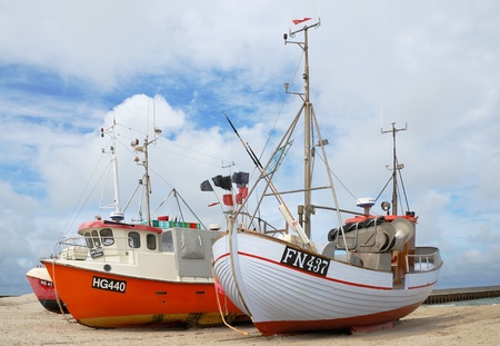 Several fishing crafts are on the sand of seacoast. The sky is overcast.のeditorial素材