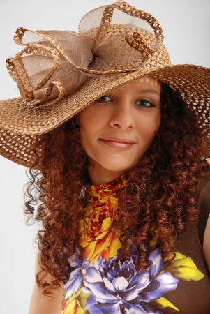 Merry young woman is wearing a summer variegated dress and the hat wide-brimmed. の写真素材
