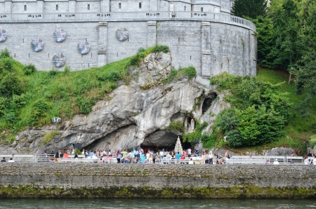 Grotto is a Catholic shrine to Our Lady in Lourdes  Pilgrims can process through the grotto and touch the rocks under the statue  Rows of benches allow visitors to sit and pray or contemplate のeditorial素材