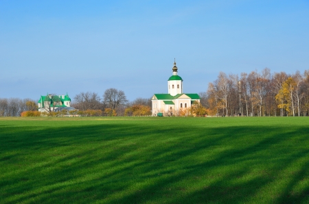 Orthodox Troitskaya church of the Motronin monastery is situated on the site of an ancient mound in the Kholodny Yar. In the foreground there is a green field as a copy space.の写真素材