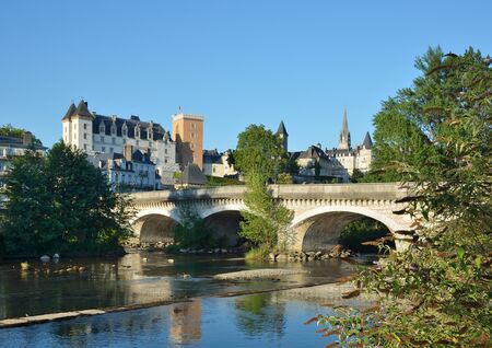 The river Gave de Pau is crossed by an ancient bridge with arches  の写真素材
