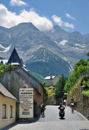 In the background there is the cirque of Gavarnie  This is a large rock amphitheater with the waterfalls in the French Pyrenees  In the foreground a mountain village is sunlit のeditorial素材