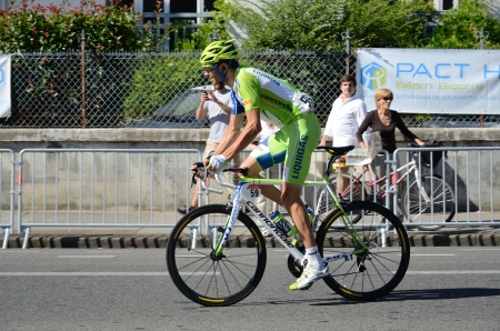 A participant of the cycle race is pedaling in the street of the French town Pau.のeditorial素材