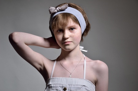 A slim teenage girl smartens herself up  She is wearing a cotton sundress and a headband の写真素材