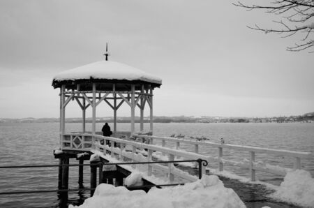 The pavilion is covered with snow on the ice-free lake Constance in the Austrian city Bregenz の写真素材