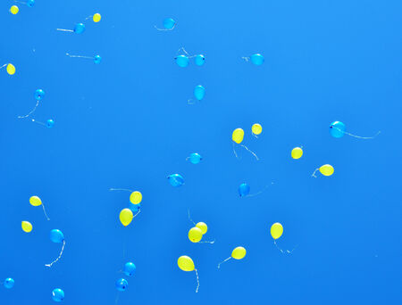 Yellow and blue balloons are flying in the clear Ukrainian sky の写真素材