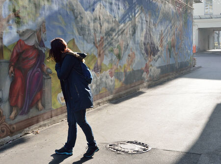 A woman views the graffiti on the outdoor wall.の写真素材