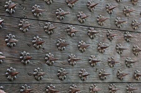 Old wooden surface is spiked with many metal thorns.の写真素材