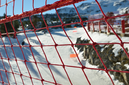 The modern red rope grid is photographed above the piste for alpine skiing.の写真素材