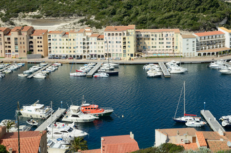There are many vessels in the harbor and residential buildings on the narrow shelf in the bottom part of Bonifacio.のeditorial素材
