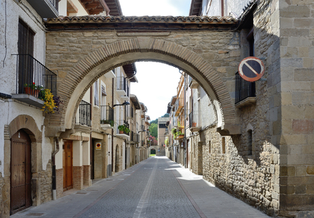 The town Sanguesa is outstanding for its historic heritage.The paved road is under the ancient arch between the stone townhouses in the old part.の写真素材