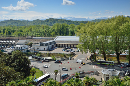 The Gare de Pau is a railway station situated in the valley. It is photographed against the forested hills and remote mountains.のeditorial素材