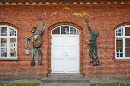 Entrance with figures of painters in the vocational university of the Danish town Jellingのeditorial素材