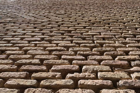 Wall of yellow bricks with cement layers Tudela Spain