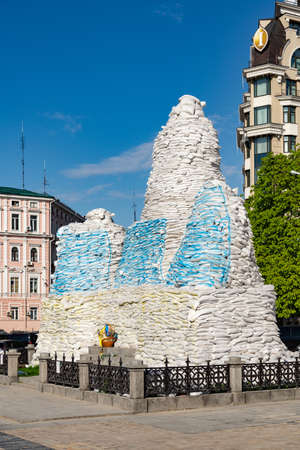 The monument to Princess Olga, Kyiv, Mykhailivska square, is covered with sandbags painted in blue...
