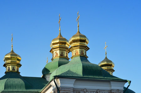 The golden domes of the Church of the Savior at Berestove shine under a clear blue sky in Kyiv,...