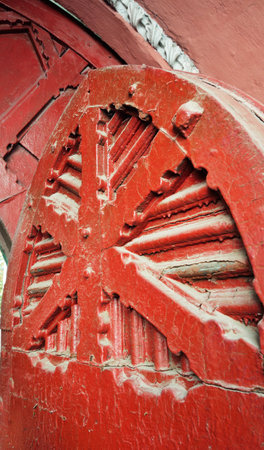 This photo captures the rich texture of ancient red wooden gates located on Yaroslaviv Val Street in Kyiv. The weathered surface, architectural detailing, and deep red color evoke a sense of history and cultural heritage. The street is known for its historical buildings and old-world charm, making this gate a symbol of the city's pastの写真素材
