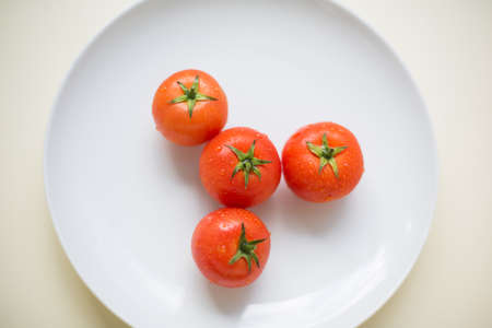 Red tomatoes on a white plateの写真素材