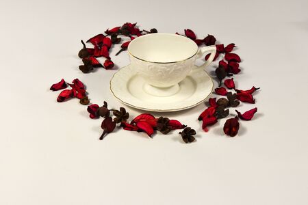 composition porcelain cup and raspberry flower petals on a white backgroundの写真素材