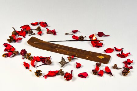 burning incense stick and flower petals on a light backgroundの写真素材