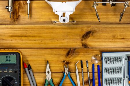 Tools for repairing phones, tablets and electronic equipment with copy space on a wooden background....