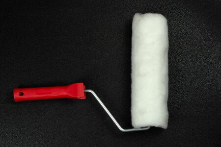 Paint roller on a black background, top view.の写真素材
