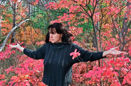 Woman with ppodnyatymi hands in the autumn forestの写真素材