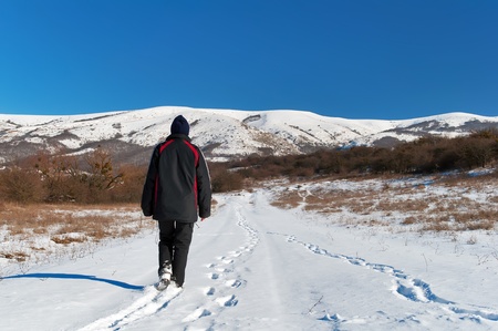 A woman walking along a snowy road in the mountains of Crimeaの写真素材