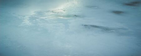 beautiful winter background the sun is reflected on the surface of the ice on the frozen riverの写真素材