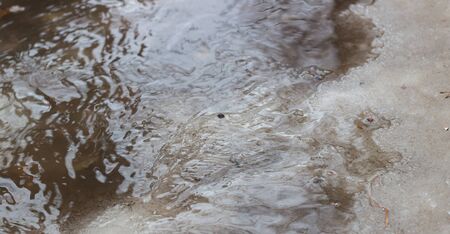 thaw in the winter when the ice begins to melt and the roads begins to flow waterの写真素材