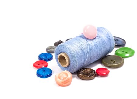 Different buttons bright and beautiful on a reel of thread