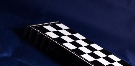 Chessboard on a fabric background, it is a very ancient game invented in India, the cells of the...
