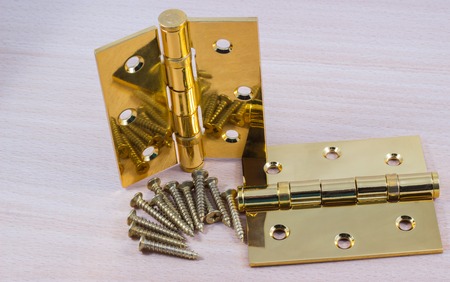 hinges on a wooden background, gold color metal