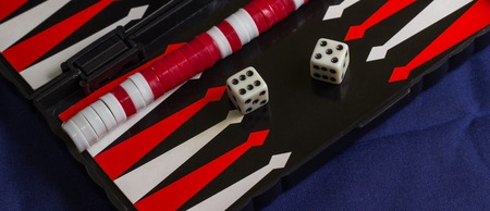 a board game in which two players move their pieces around twenty-four triangular points according to the throw of dice, the winner being the first to remove all their pieces from the boardの写真素材