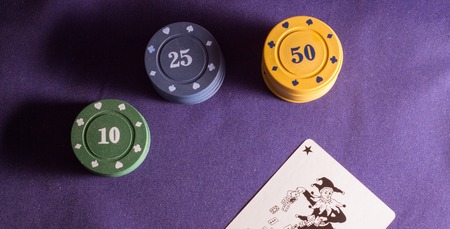 poker chips and joker on the background fabric, items for table games