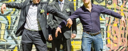 Guys in business suits on the background of a painted brick wallの写真素材