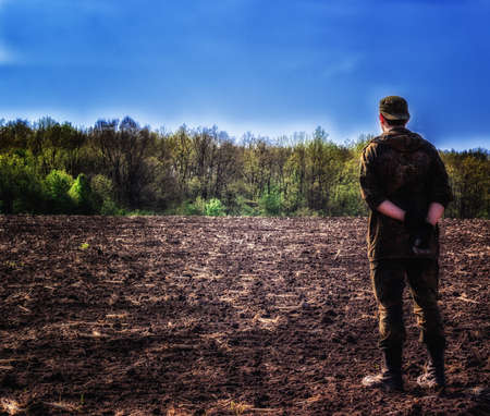 A man is standing on the field admiring the magical view of the forestの写真素材