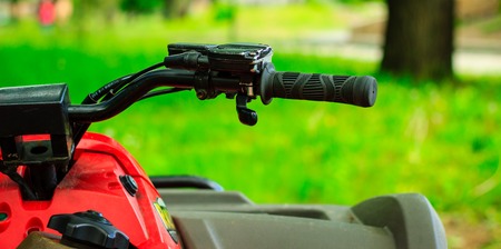 Front part of a red motorcycle on a blurred background of nature summer season all greenの写真素材